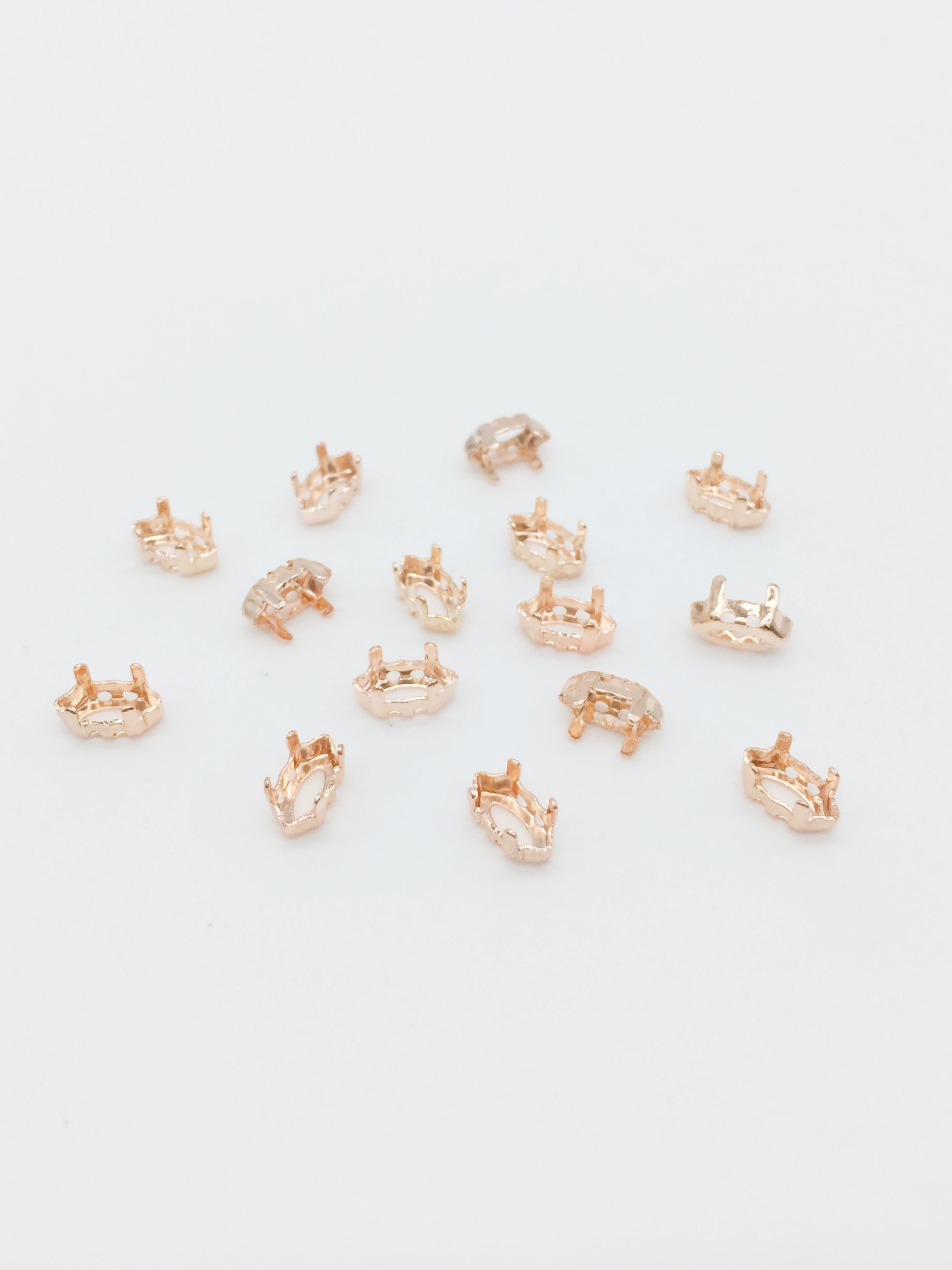 A pack of 24 rose gold plated brass sew-on settings for marquise cut stones.